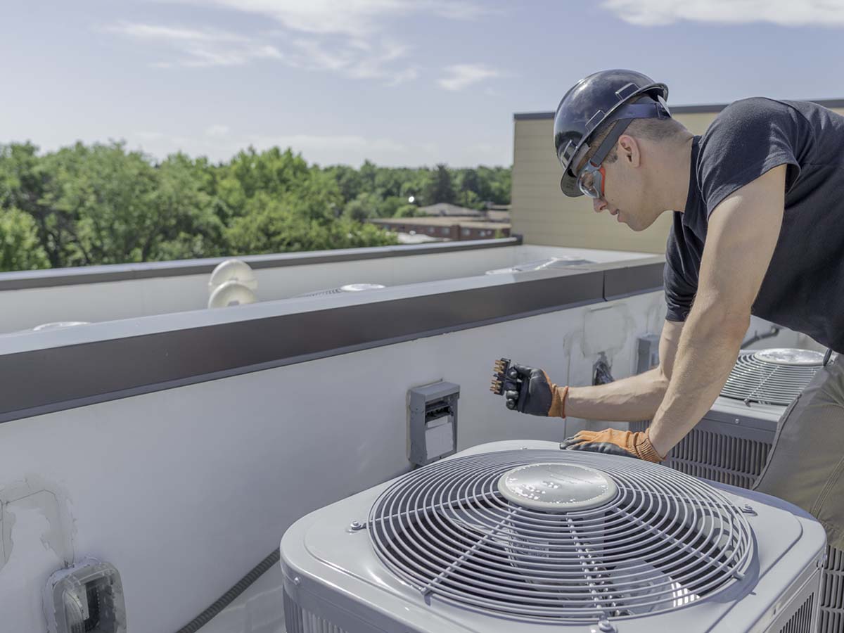 An image of a man checking a commercial HVAC unit.
